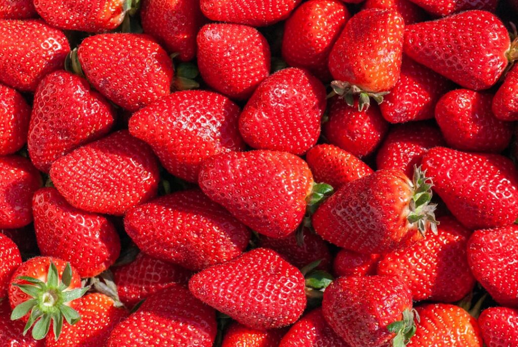 Bowl of fresh ripe strawberries gleaming and ready for use in a recipe