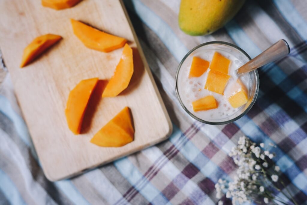 A bright and refreshing bowl of Tropical Mango Coconut Oats featuring creamy oats topped with fresh diced mango and a sp