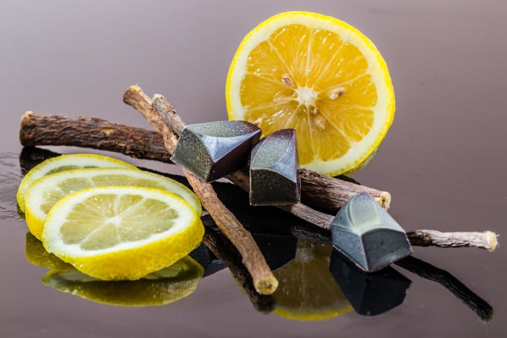 Close-up of a small bowl containing activated charcoal powder and fresh lemon slices beside it ready to be mixed