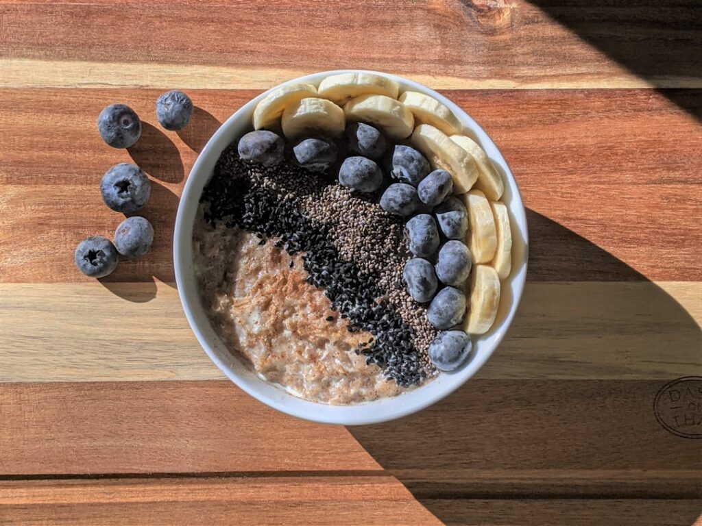 A beautifully composed shot of a warm chia pudding bowl steam gently rising topped with stewed cinnamon apples pecans an