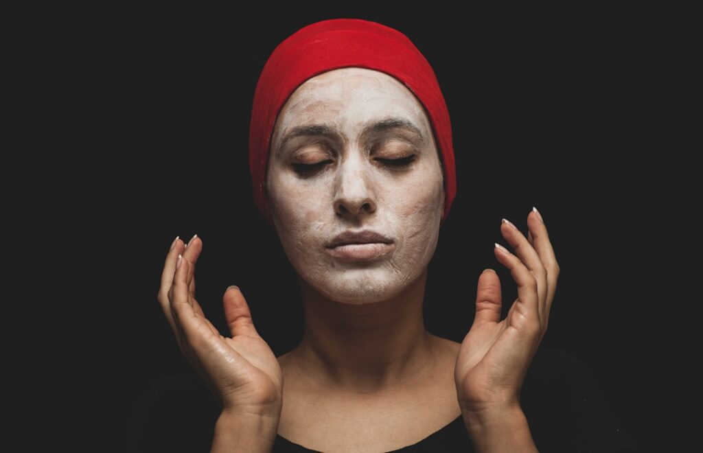 A woman gently applying a paste made from the herbal cleansing powder to her face eyes closed in tranquility reflecting 