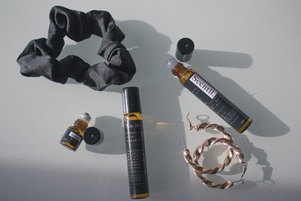A woman gently massaging a natural oil blend into her scalp with a serene expression surrounded by subtle natural light