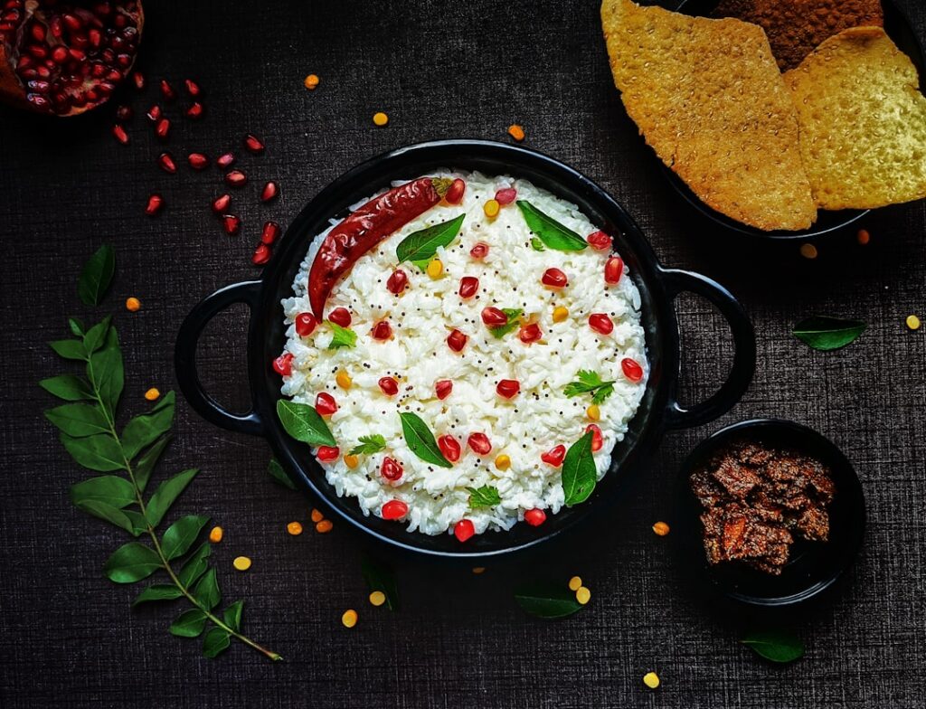 A creamy cottage cheese dip in a small white bowl surrounded by an assortment of vibrant fresh vegetable sticks like car