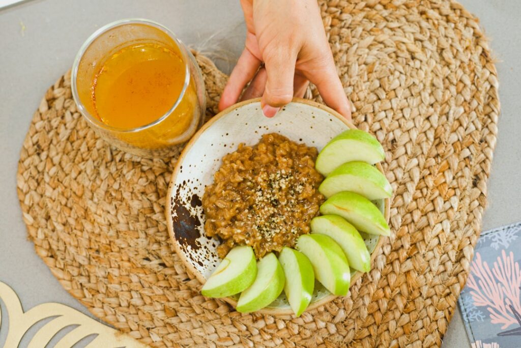 A vibrant and aesthetically pleasing bowl of oat milk chia pudding mixed with rolled oats topped with fresh sliced apple
