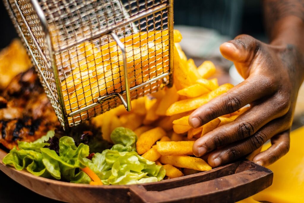 A modern air fryer with its basket open showcasing a variety of vibrant healthy vegetables and lean protein cuts ready f