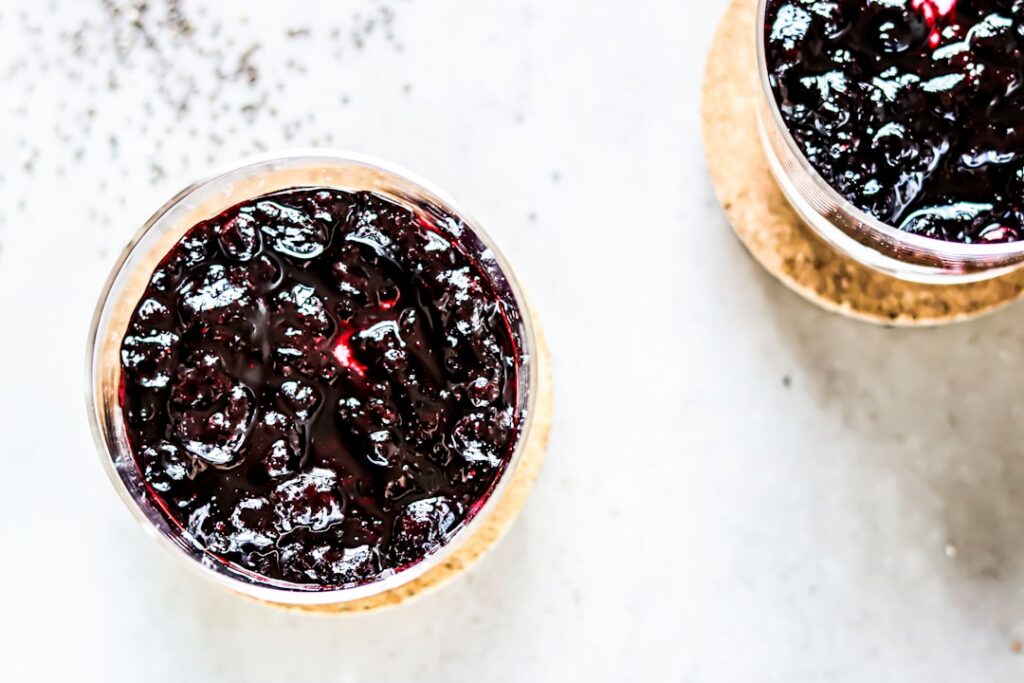 A vibrant and clean close-up of two glass jars of chia pudding one with a distinctly creamy smooth texture and the other