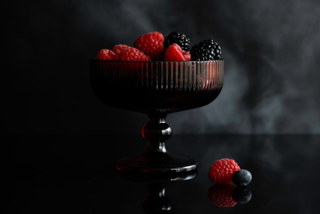 A beautifully layered Classic Berry Trifle in a clear glass bowl showing distinct layers of pound cake fresh mixed berri