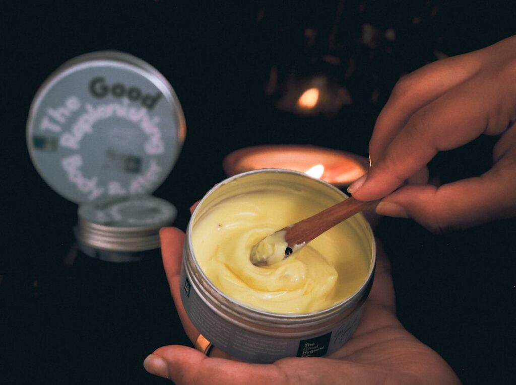 A close-up of hands applying a creamy balm or mask showing a gentle self-care moment The hands appear soft and well-care