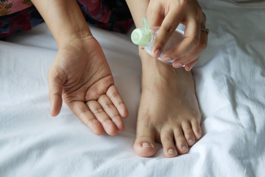 A close-up of a hand gently massaging infused baby oil onto clean skin