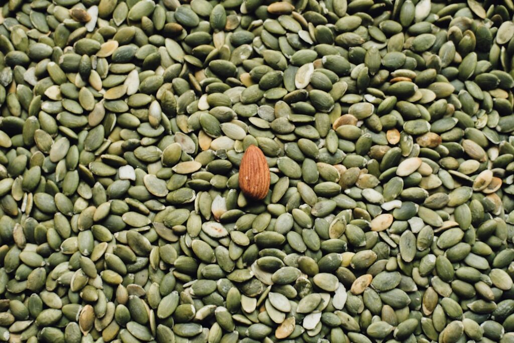 Close-up of a bowl containing whole pumpkin seeds and flax seeds showcasing their natural texture and color