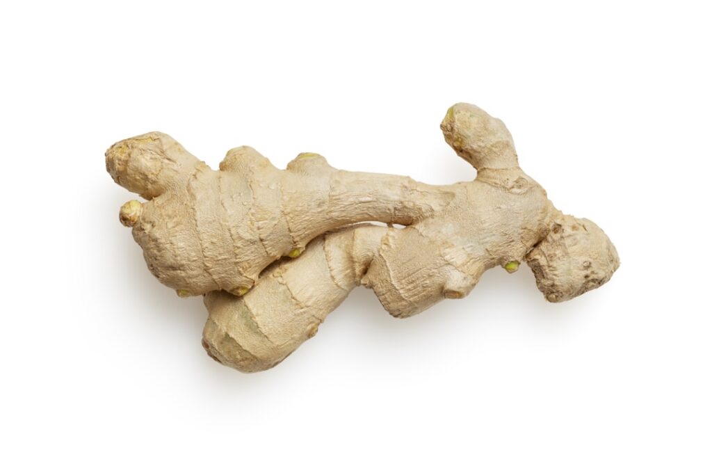 A person gently placing a warm damp ginger compress on their shoulder or back illustrating the application of the remedy