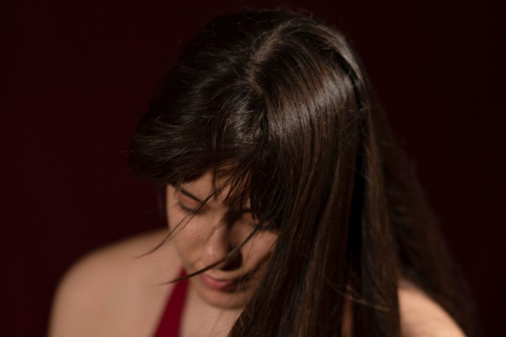 A close-up of a woman s healthy shiny dark hair demonstrating natural luster and strength after a transformative natural