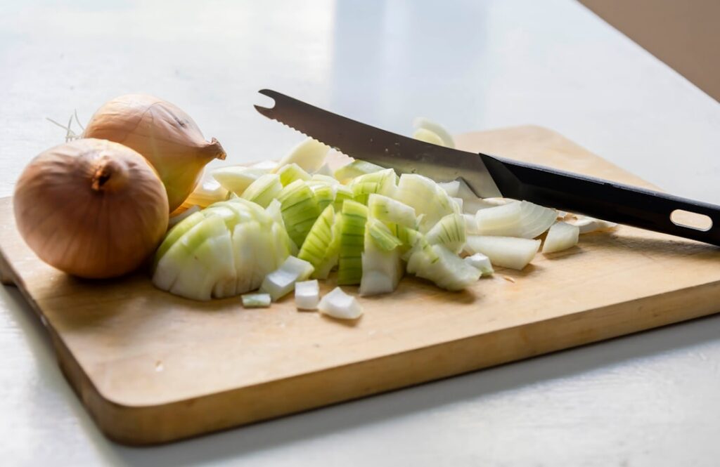 Close-up of freshly sliced red onions on a wooden cutting board ready for application