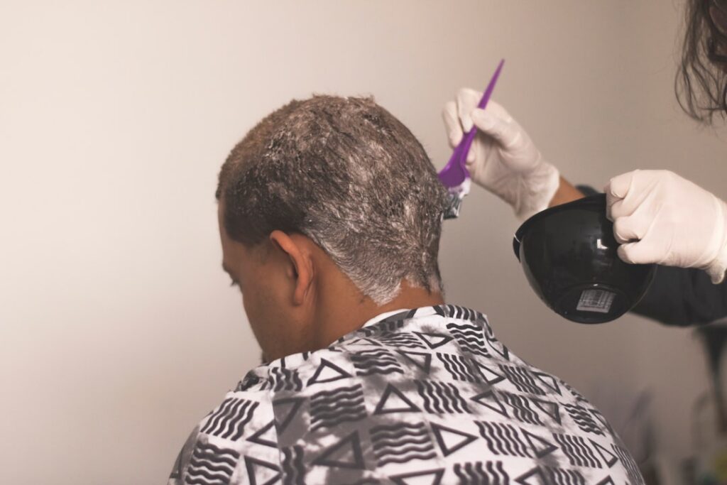 A before and after comparison showing a scalp with significant grey hair regrowth transitioning to uniformly rich dark b