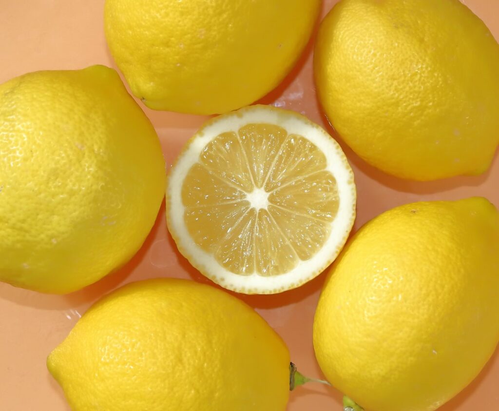 Close-up of a jar of Vaseline petroleum jelly and fresh sliced lemons