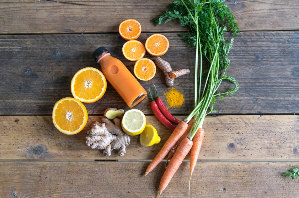 A close-up of a person s hands preparing fresh fruits and vegetables like pineapple turmeric ginger and celery for juici
