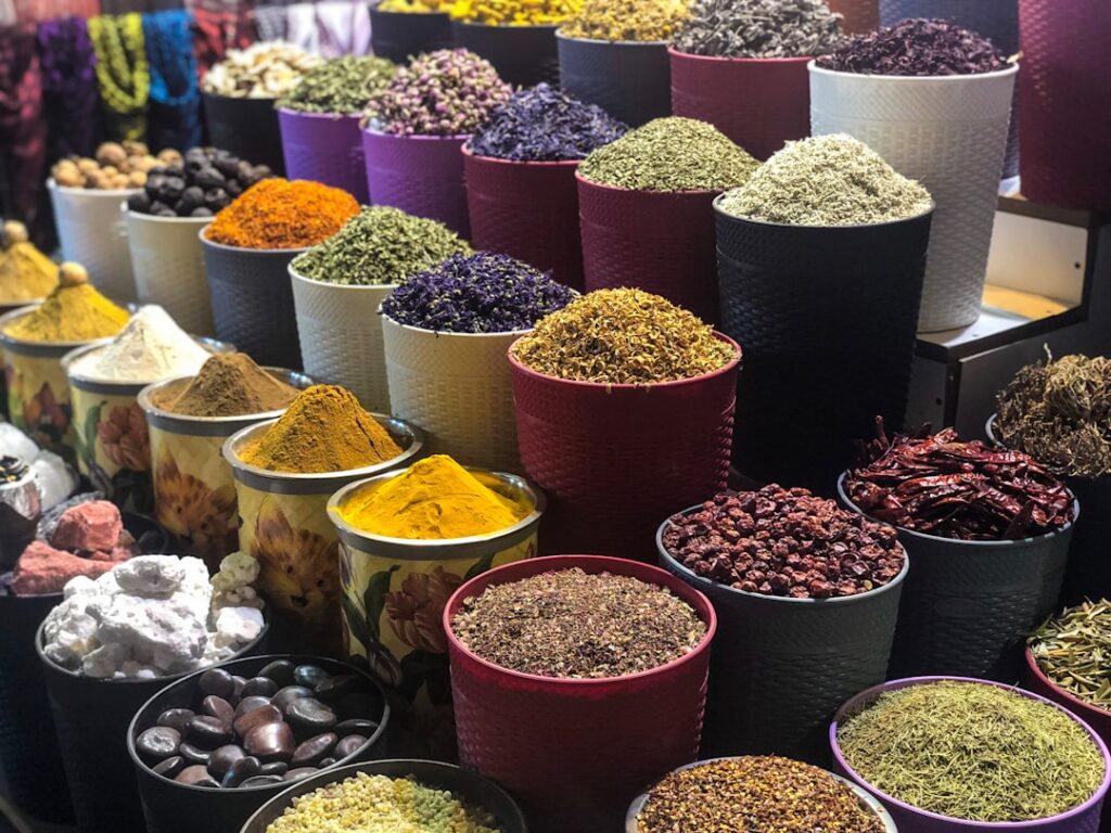 A variety of individual spices and dried herbs arranged in small bowls ready to be mixed into custom blends