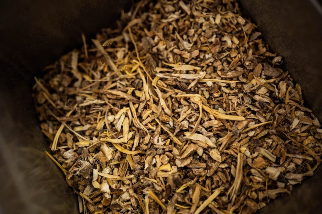 Cleaned and chopped dried Cỏ Tranh roots ready for brewing in a saucepan