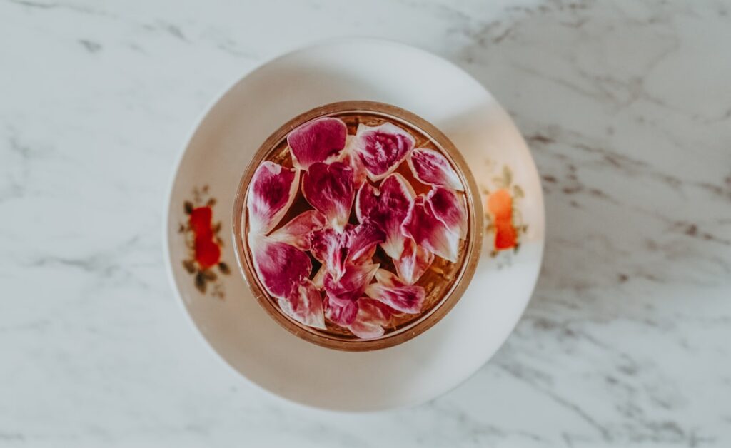 Sliced red onions steeping in a glass jar with water covered