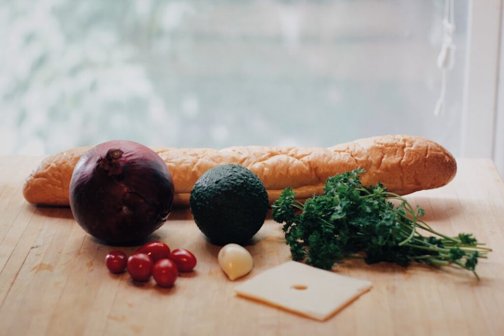A variety of beautifully arranged sub sandwich ingredients on a cutting board ready for assembly showcasing fresh vegeta