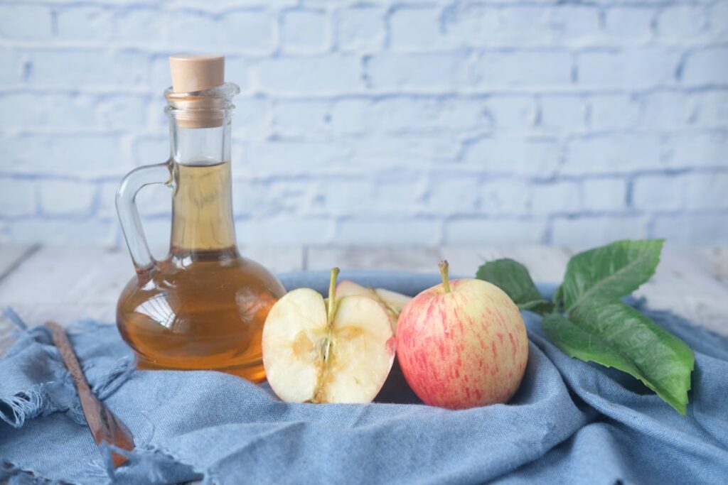 Ingredients for a nighttime cleanse fresh lemons a bottle of apple cider vinegar a jar of honey and a glass of warm wate