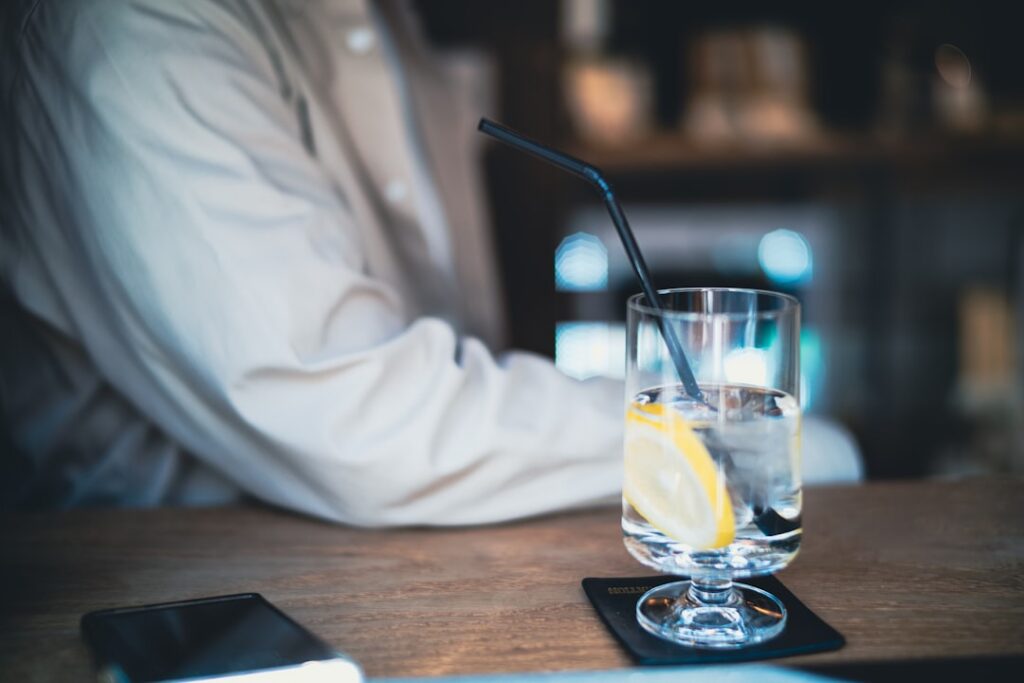 A person drinking a warm beverage through a straw to protect tooth enamel