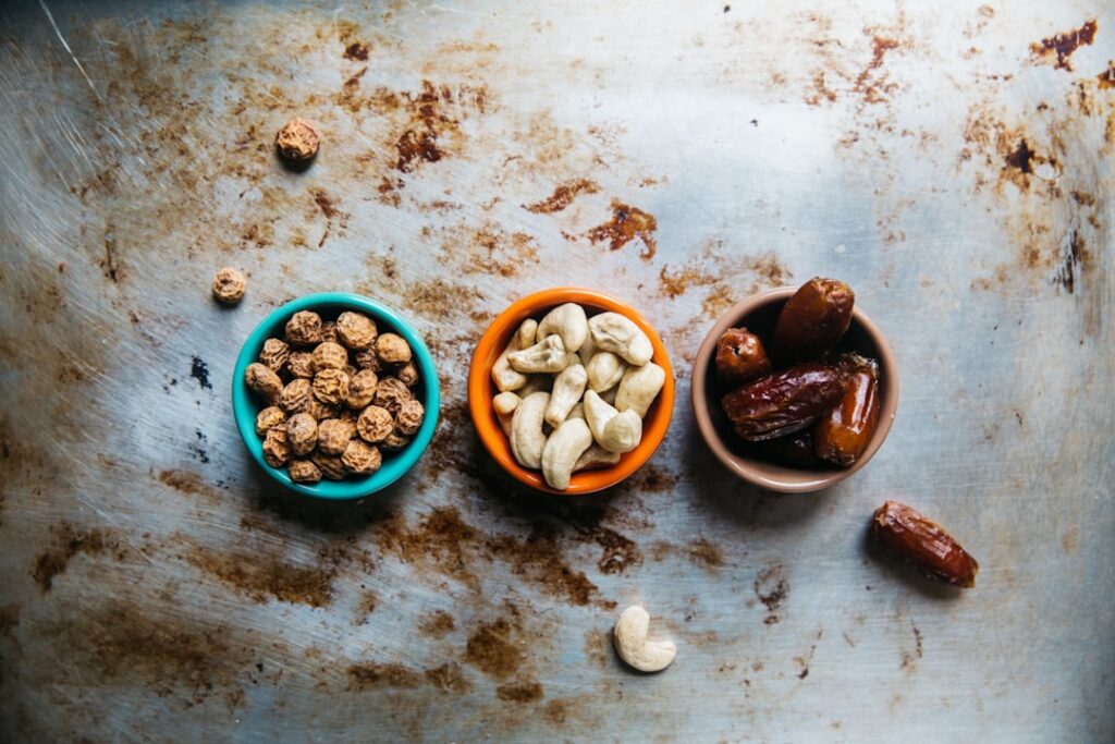 An assortment of plant-based iron sources including lentils spinach fortified cereal pumpkin seeds tofu and beans in sep