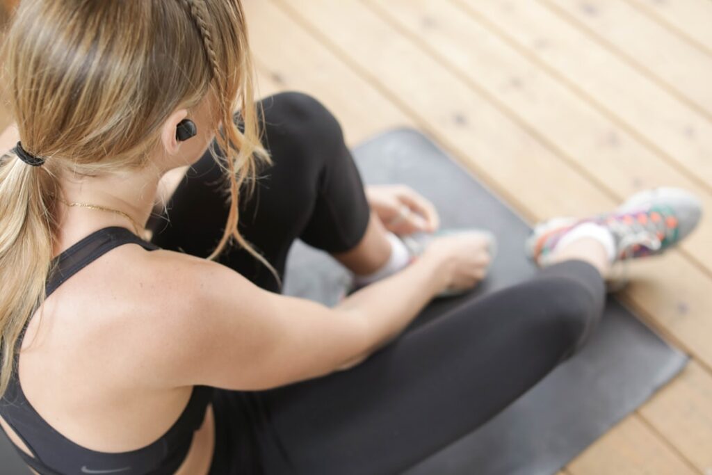 A person demonstrating the heel slide exercise with proper form lying on their back slowly sliding one heel towards thei