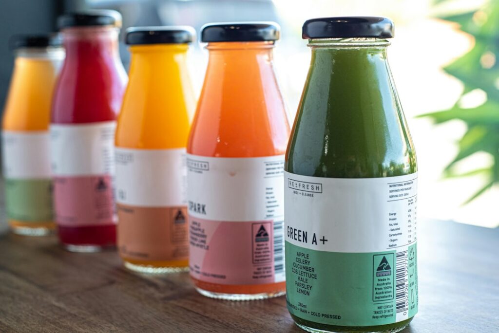 A vibrant aesthetically pleasing collection of various healthy drinks such as a green smoothie a berry smoothie a lemon-
