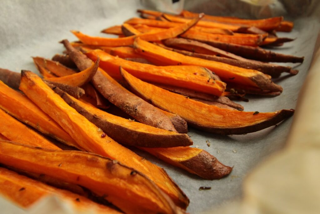 A perfectly baked sweet potato split open lengthwise with steam gently rising ready for toppings The potato has a slight