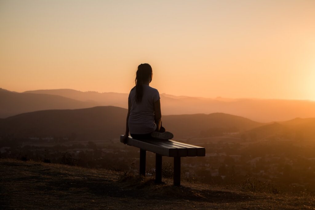A person practicing gentle yoga or meditation outdoors in a serene natural setting embodying peace and wellness