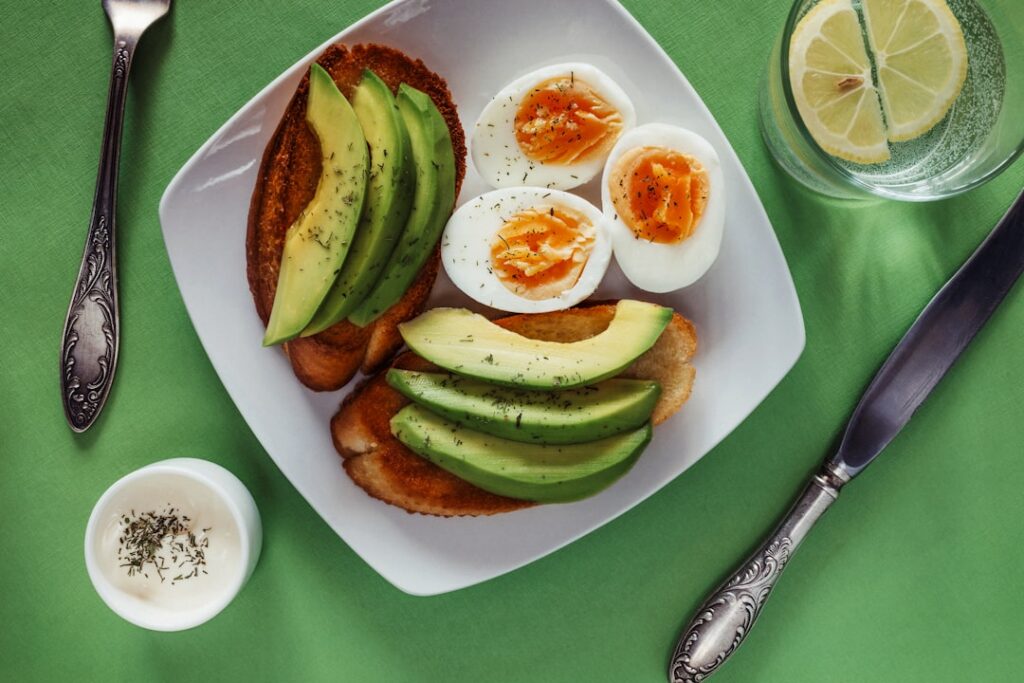 A vibrant balanced meal featuring various healthy fat sources like avocado salmon and olive oil dressing