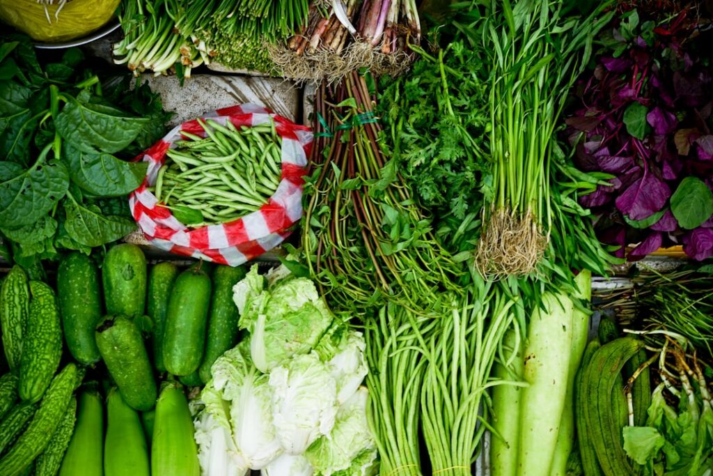 A vibrant and colorful collage of various green leafy vegetables like spinach kale collard greens and broccoli arranged 