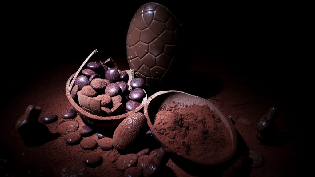 Dark chocolate pieces or cocoa powder in a rustic bowl possibly with some cacao beans nearby emphasizing its rich natura