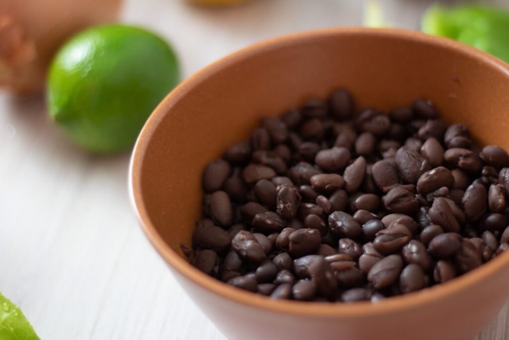 A bowl of cooked lentils and a separate bowl of black beans showing the volume needed for a 30g protein serving