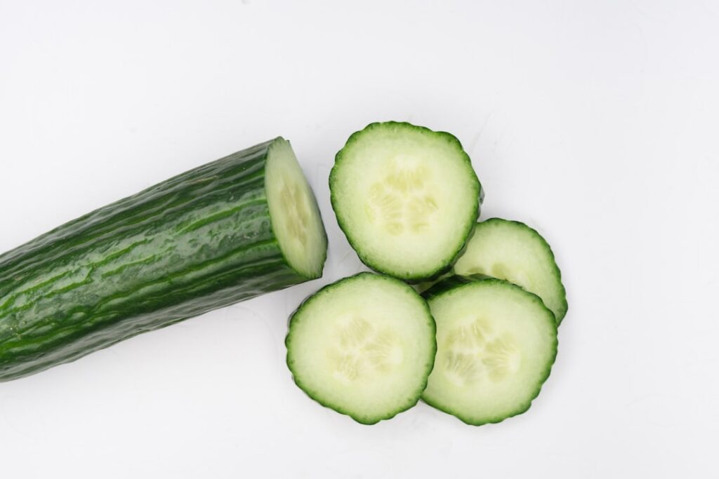 Fresh slices of cucumber and lime arranged neatly on a cutting board or small plate ready for use in a DIY beauty treatm