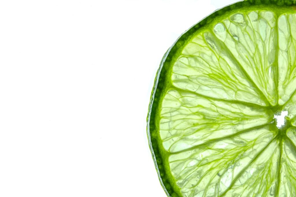 Close-up of a person gently dabbing a cotton pad soaked in the lime and cucumber mixture under their eye demonstrating t