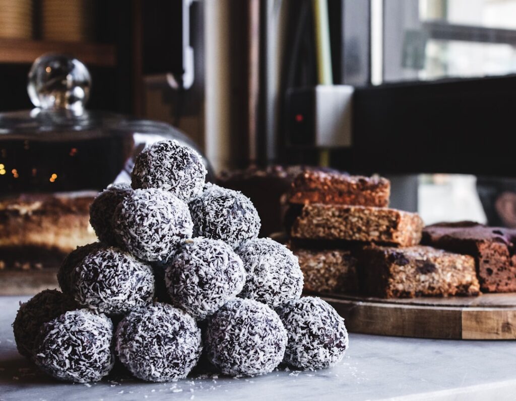A close-up shot of several vegan brownie bliss balls stacked or arranged artfully perhaps sprinkled with cacao powder or