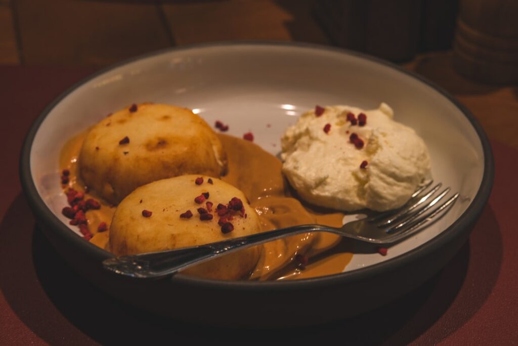 Close-up of a perfectly baked apple golden brown and slightly collapsed with a glistening sweet syrup and a sprinkle of 