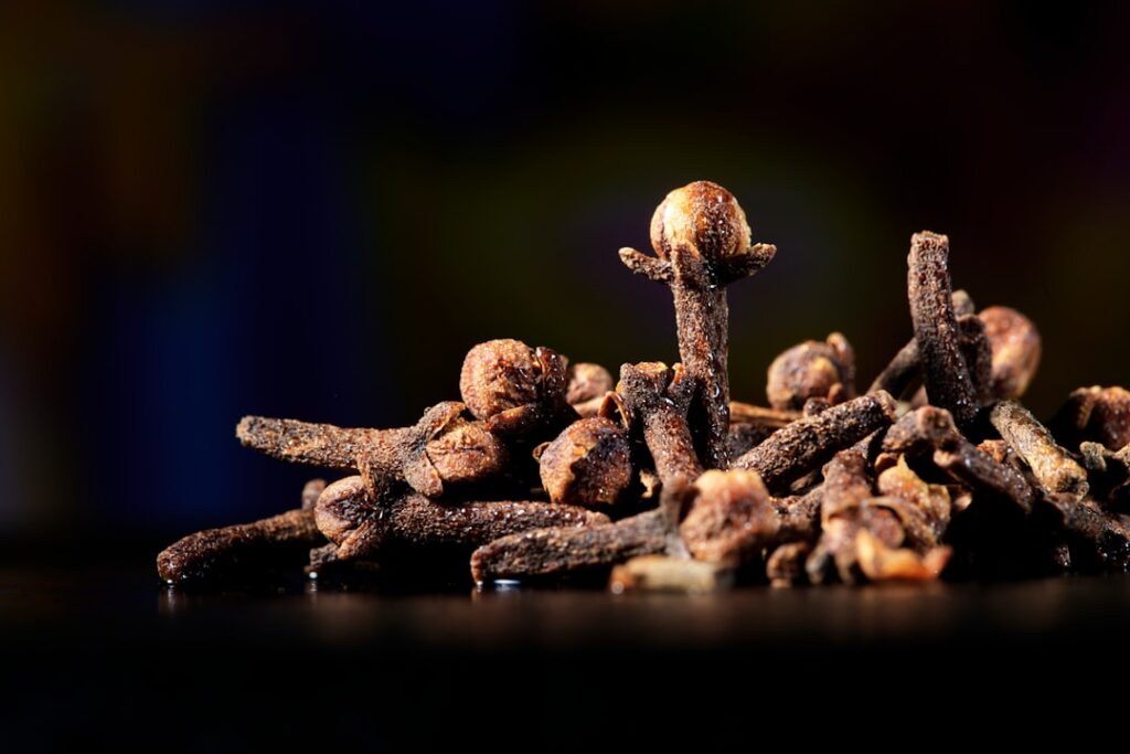 Close-up of whole dried cloves on a wooden surface ready for use in a natural remedy