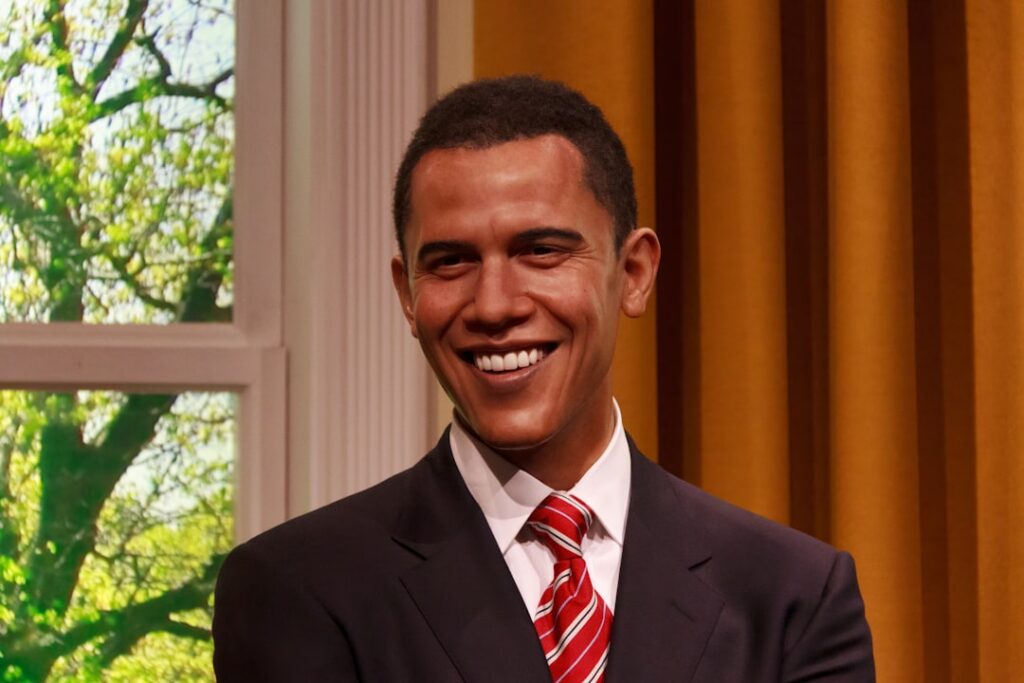 A younger Barack Obama in a professional setting possibly a courtroom or classroom looking engaged and serious represent
