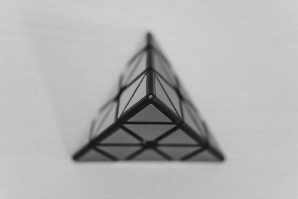 A complex geometric drawing featuring many overlapping triangles forming a larger intricate shape designed as a brain te