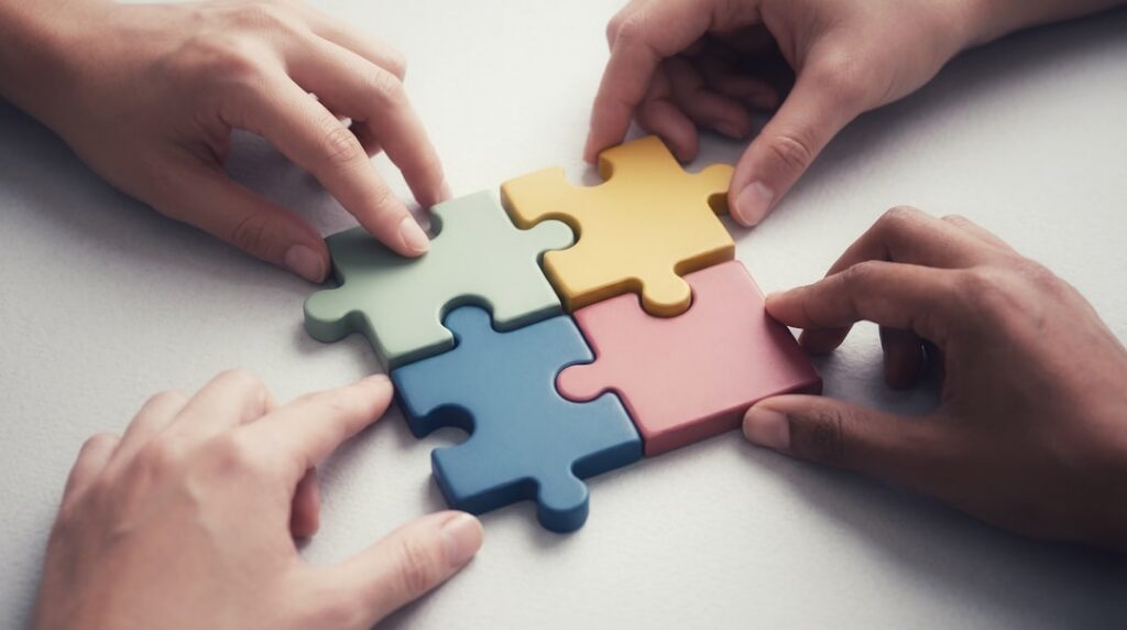 A group of diverse people laughing and interacting with a puzzle on a tablet showcasing fun and engagement