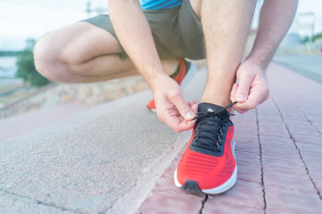 A person lacing up their running shoes symbolizing the start of a fitness journey