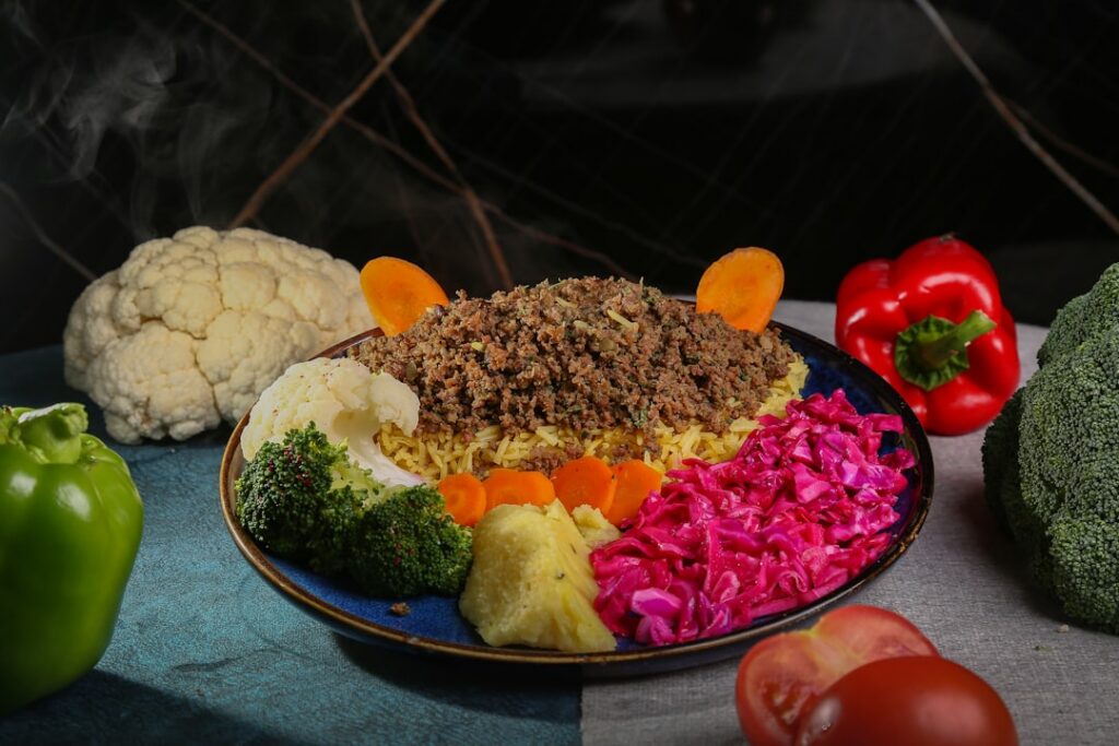 A plate showing approximately 350-400g of cooked lean ground beef or steak illustrating the quantity needed for 100g of 