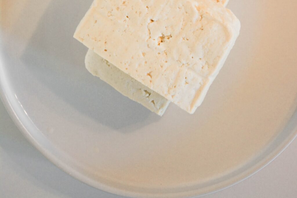 A block or servings of approximately 1 25 kilograms 1250g of firm tofu illustrating the quantity needed for 100g of prot