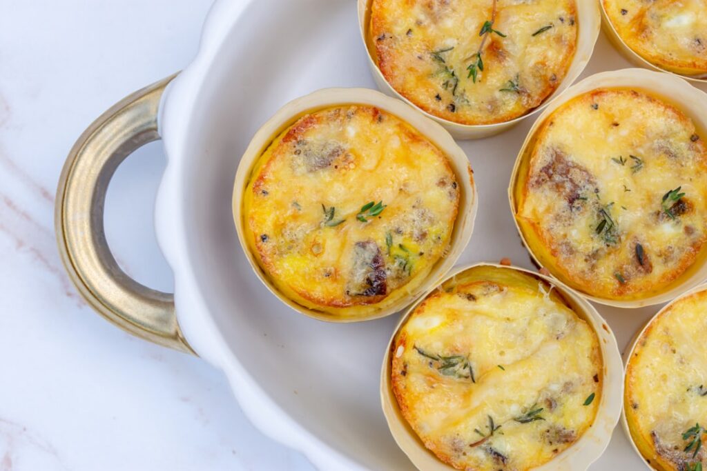 Small perfectly portioned keto egg bites with visible bacon bits and a light golden crust