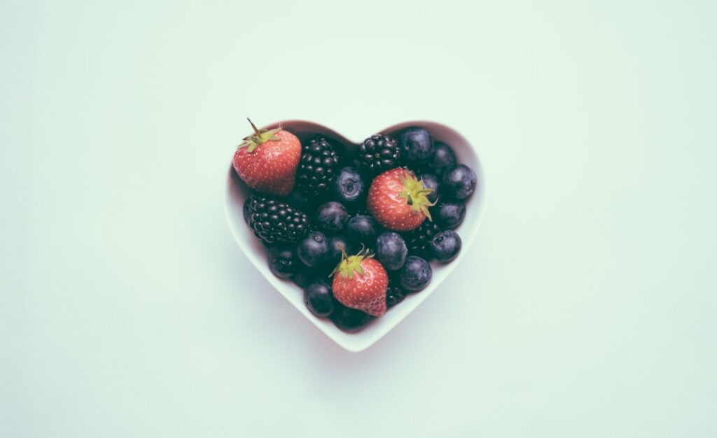 A vibrant mix of heart-healthy foods including salmon blueberries walnuts and a bottle of olive oil arranged aesthetical