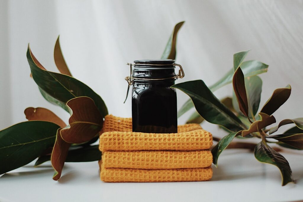 A beautiful flat lay of ingredients for the clove infused face oil whole cloves small bottles of sweet almond oil and jo