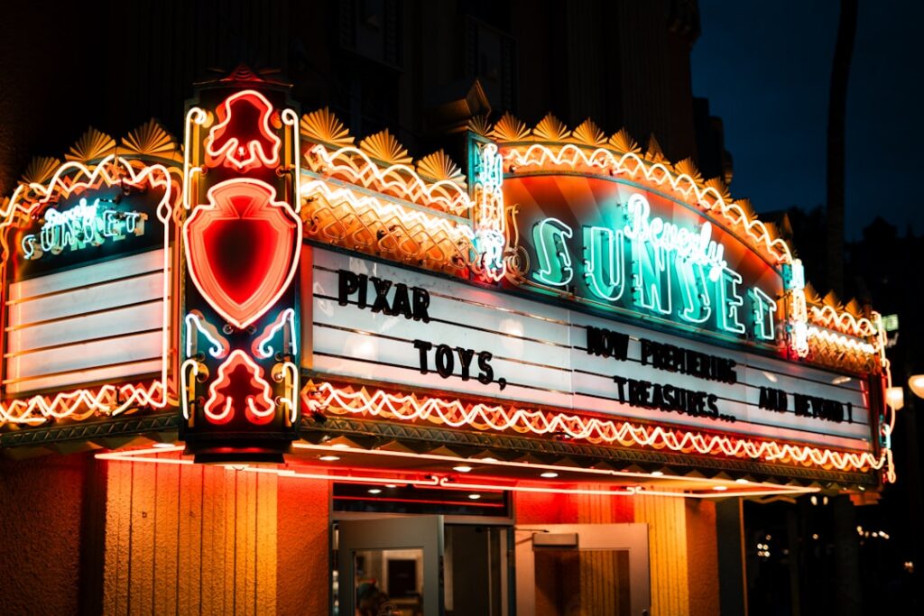 A vintage movie theater marquee from 1980 displaying an old film title and people lining up to buy tickets The scene sho